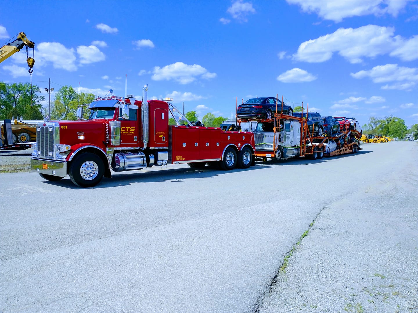 heavy towing truck pulling semi truck loaded with other vehicles