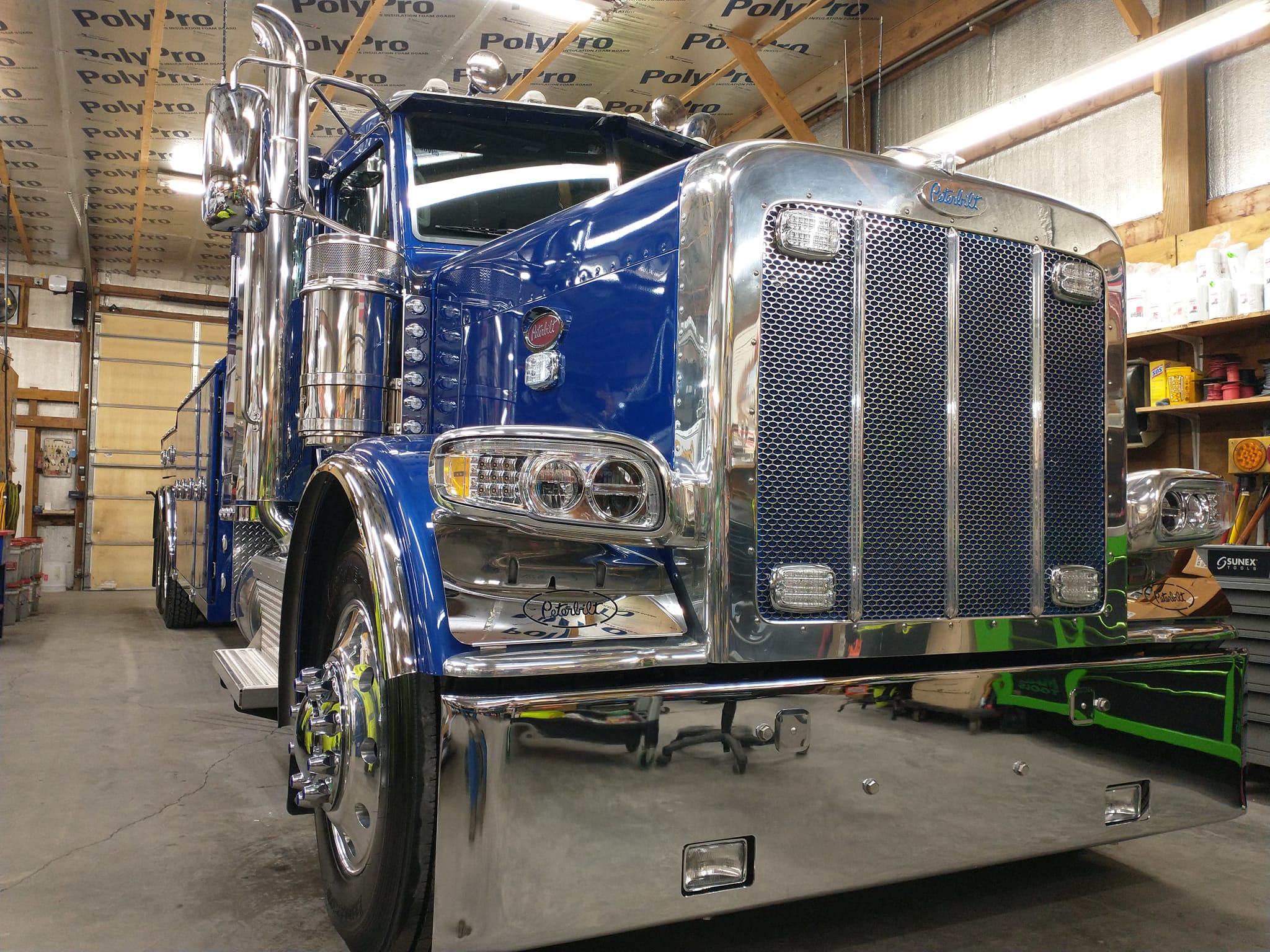 front of blue tow truck in garage