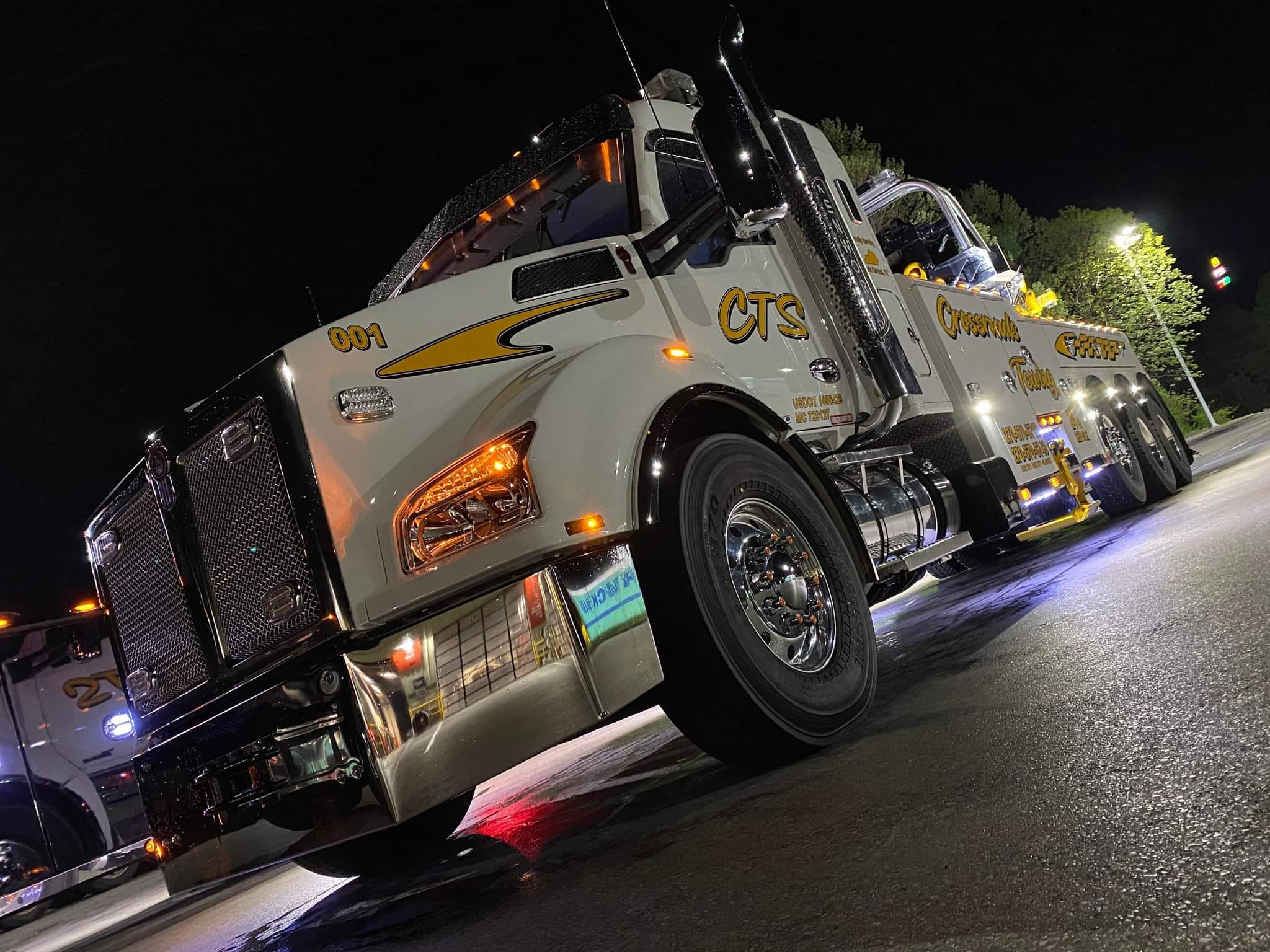 white tow truck at night with lights