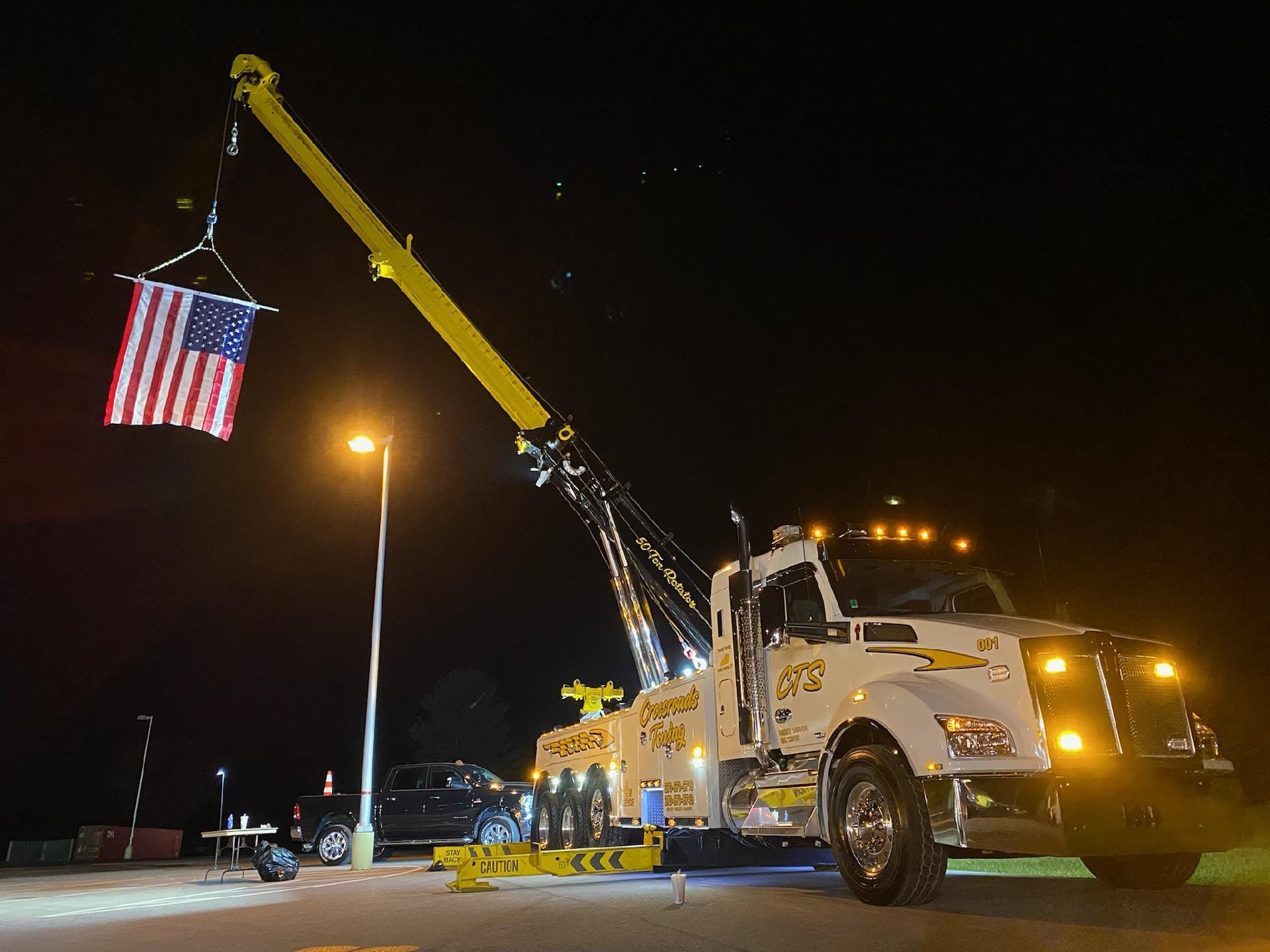 crane truck lifting up American flag
