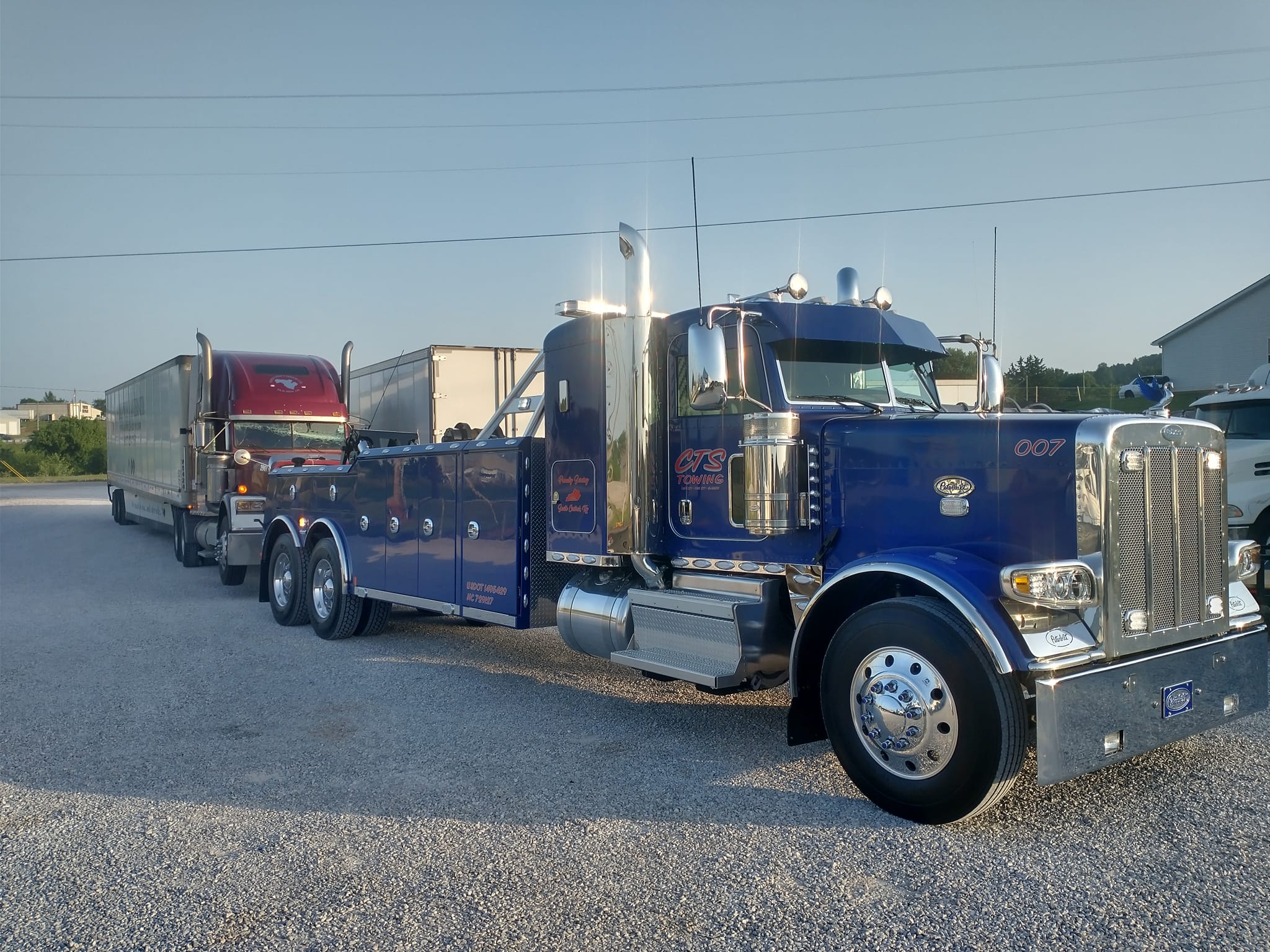 blue tow truck hauling semi truck