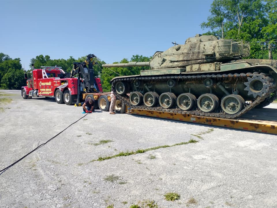 heavy towing truck hauling a military tank