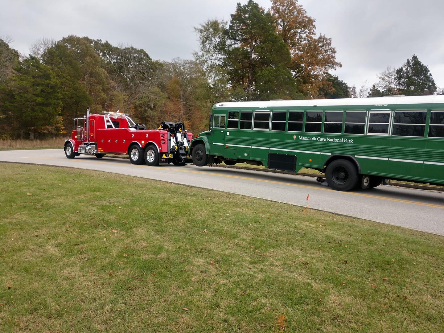 red tow truck pulling national park bus
